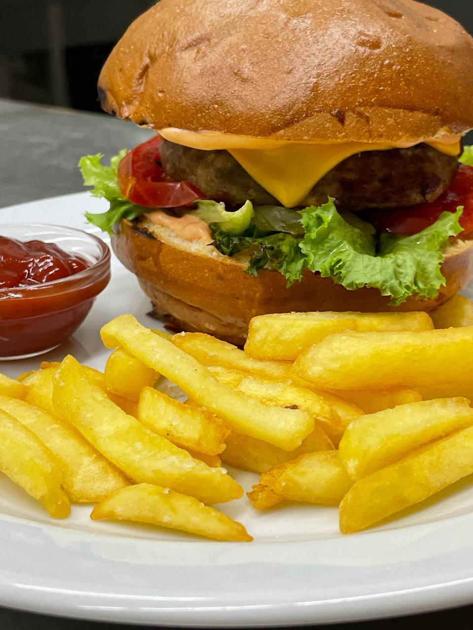 Бургер з яловичою котлетою в булочці бріош та картопля фрі